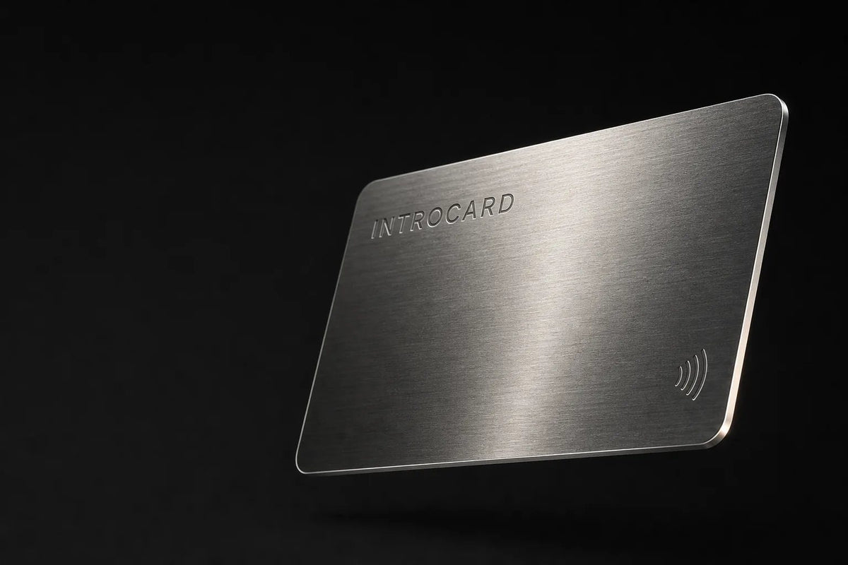 Burnished silver Introcard with laser-engraved wordmark and contactless symbol, floating against black